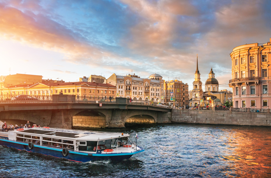 Прогулочный катер с туристами у моста Белинского через реку Фонтанку в Санкт-Петербурге