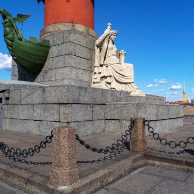 Sculpture on the Rostral column against the background of the Peter and Paul Cathedral.