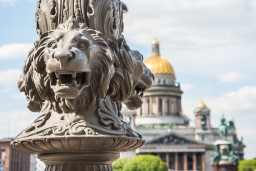 St. Isaac's Cathedral out of focus, in the foreground the sculpture of lions on a pole, Saint-Petersburg, Russia.