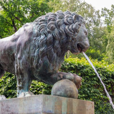 Bronze statue of lion. Fragment of fountain Lion's cascade in Lo