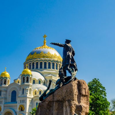 statue-man-hat-stands-front-church-with-golden-dome-background