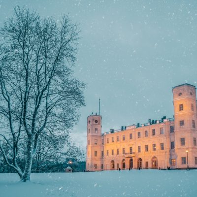 The old palace in winter is illuminated in the evening.