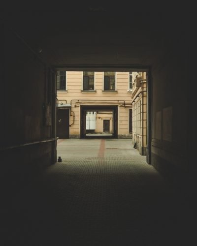 Vertical shot of a dark archway  with a building visible in the background