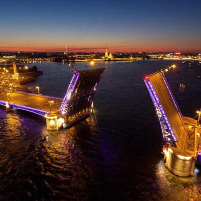 Aerial night landscape of festivities on palace embankment at bridge drawing in St. Petersburg, Russia, picturesque night illumination of landmarks, a lot of pleasure boats, a lot of people