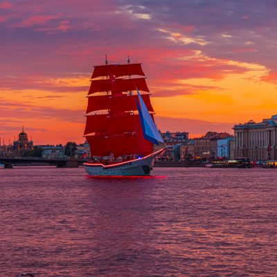 Brig with scarlet sails on the Neva. Fantastic fiery sunset.
