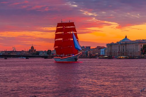Brig with scarlet sails on the Neva. Fantastic fiery sunset.