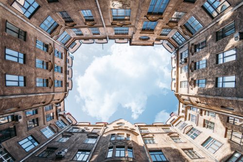enclosed-courtyard-of-old-residential-house-in-saint-petersburg-russia-blue-cloudy-sky-copy-space