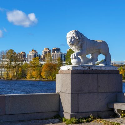 Sculpture of a lion with a ball on the background of the building Lakhta center. Elagin island. Saint Petersburg.