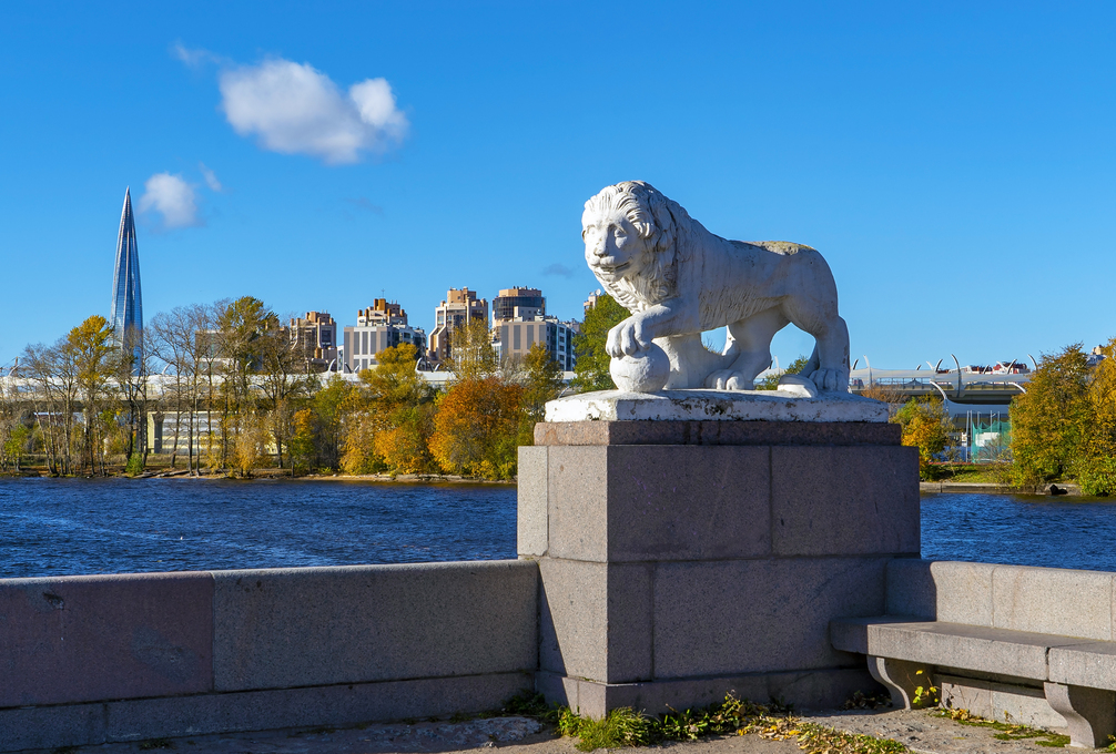 Sculpture of a lion with a ball on the background of the building Lakhta center. Elagin island. Saint Petersburg.