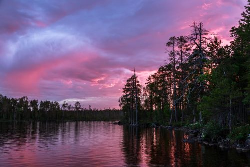 Red sunset and sunrise over the forest and lake  during the whit