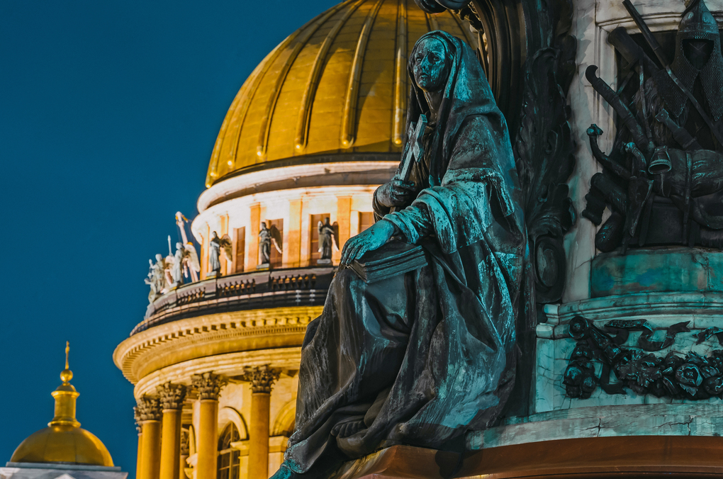 Night view of the ancient statues of stucco and the dome of St. Isaac's Cathedral Saint-Petersburg.