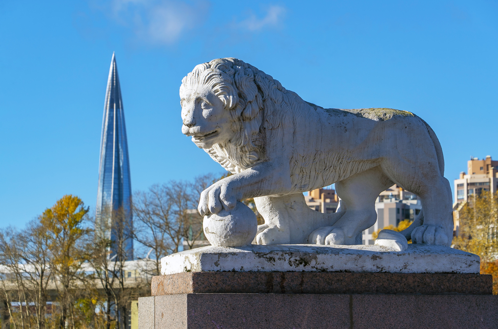 Sculpture of a lion with a ball on the background of the building Lakhta center. Elagin island. Saint Petersburg.